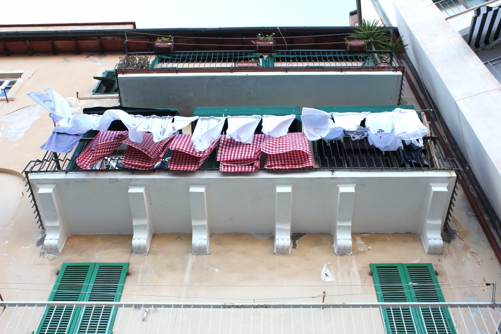 altan med vasketøj, rød og hvidternede duge fra restauranten hænger til tørre.