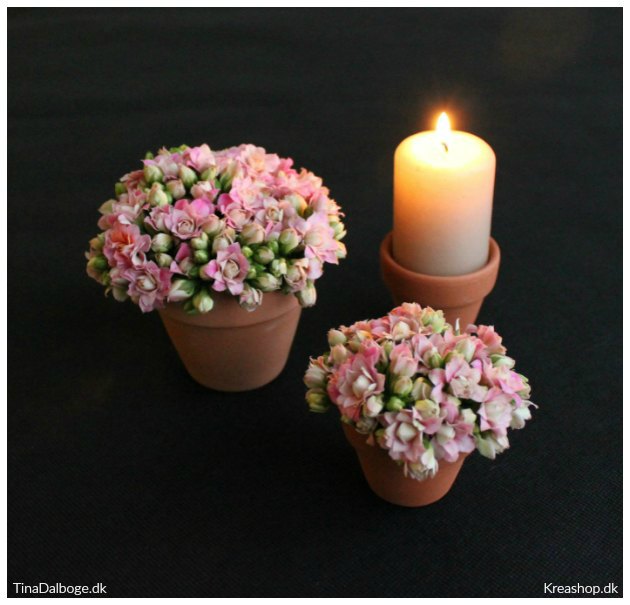 borddækning med blomster og lys i små urtepotter