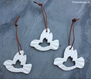diy julepynt duer lavet af hvidt ler med ophæng af lædersnøre